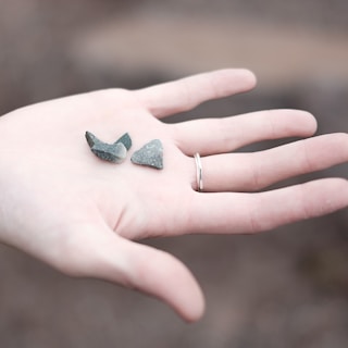 three gray pebbles on person's palm