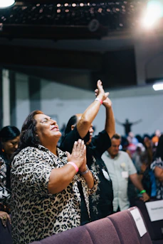 A screenshot of a joyful Zoom meeting with smiling faces engaged in worship and discussion.