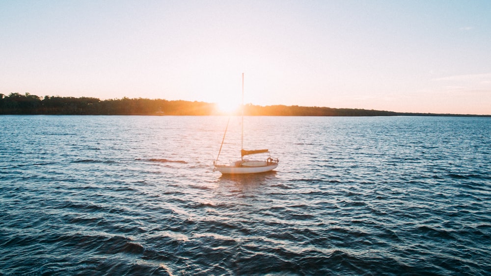 white sailing boat on body of water