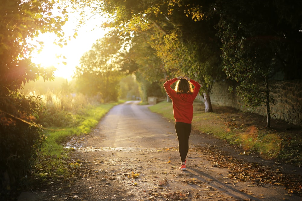 Mujer que camina por el camino durante el día