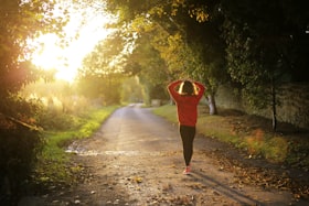 Mulher com roupa esportiva caminhando no amanhecer