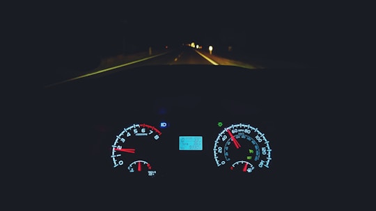 A sleek modern car dashboard with a glowing speedometer at dusk.