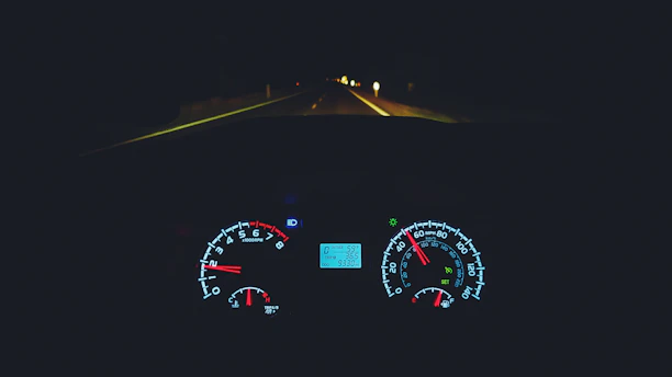 A sleek car dashboard with a glowing digital speedometer at dusk.