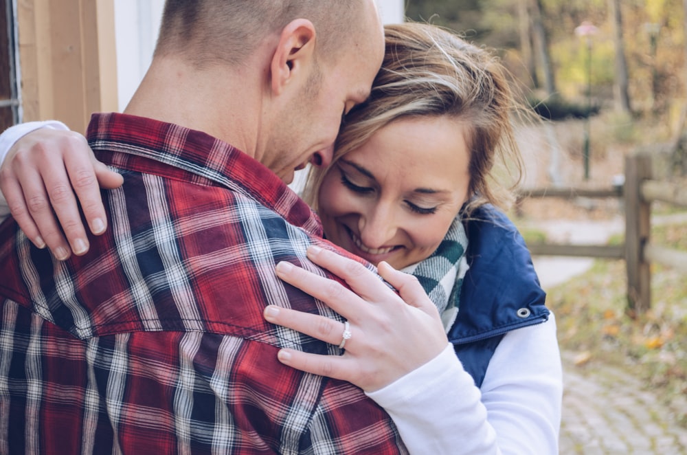 man and woman embracing beside wall