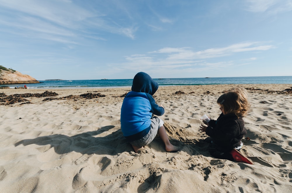 two kid in sand during daytime