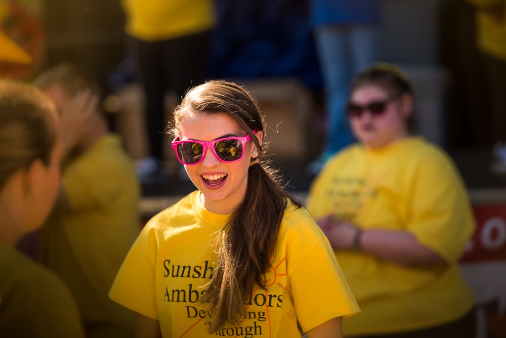 smiling girl wearing pink framed sunglasses