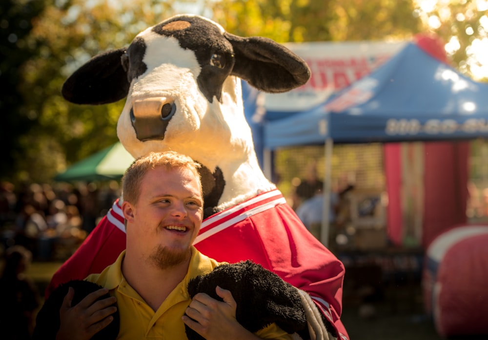 Uomini vicino alla mascotte della mucca 