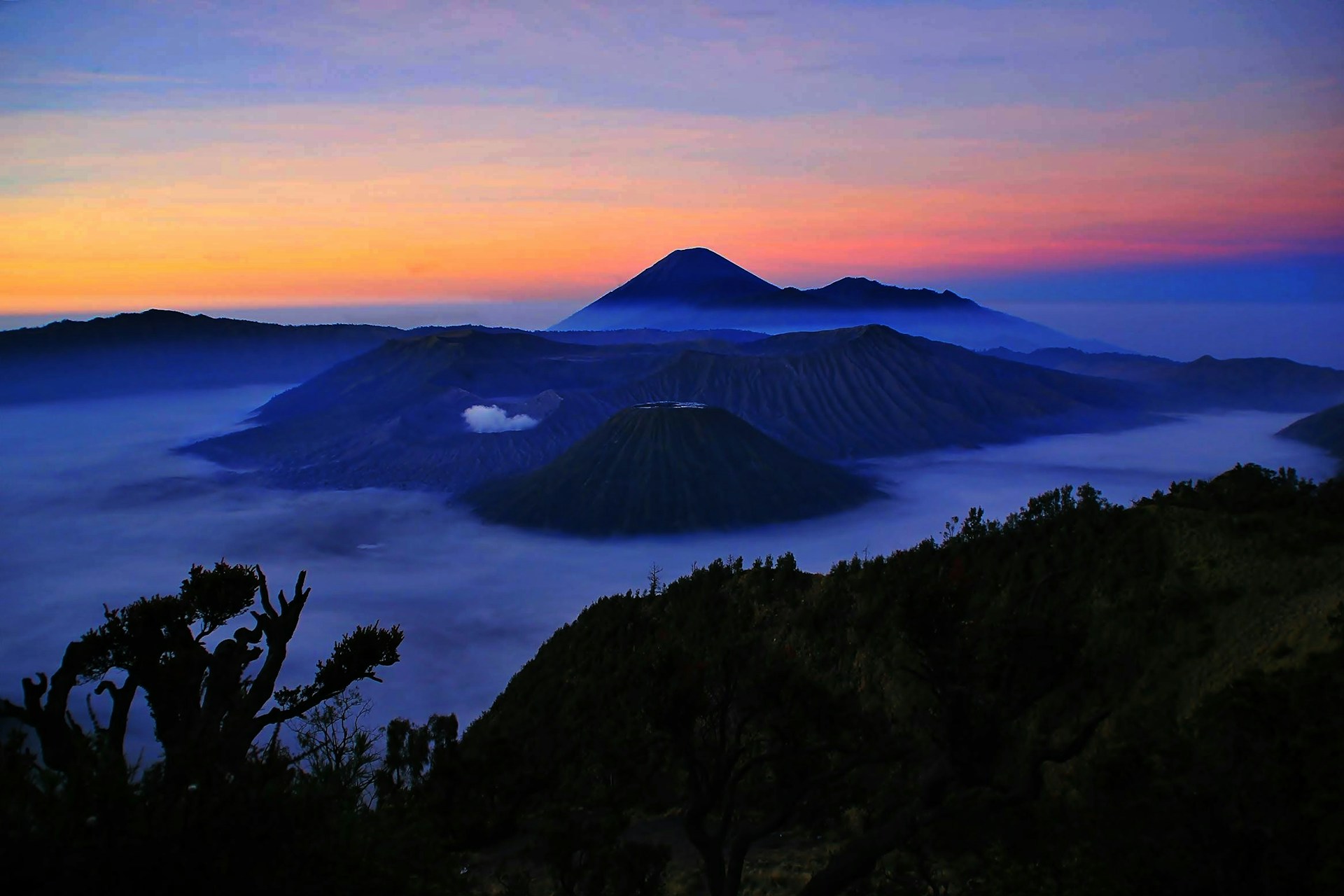 A breathtaking sunrise over Mount Bromo with a sea of mist swirling around the volcanic peaks.