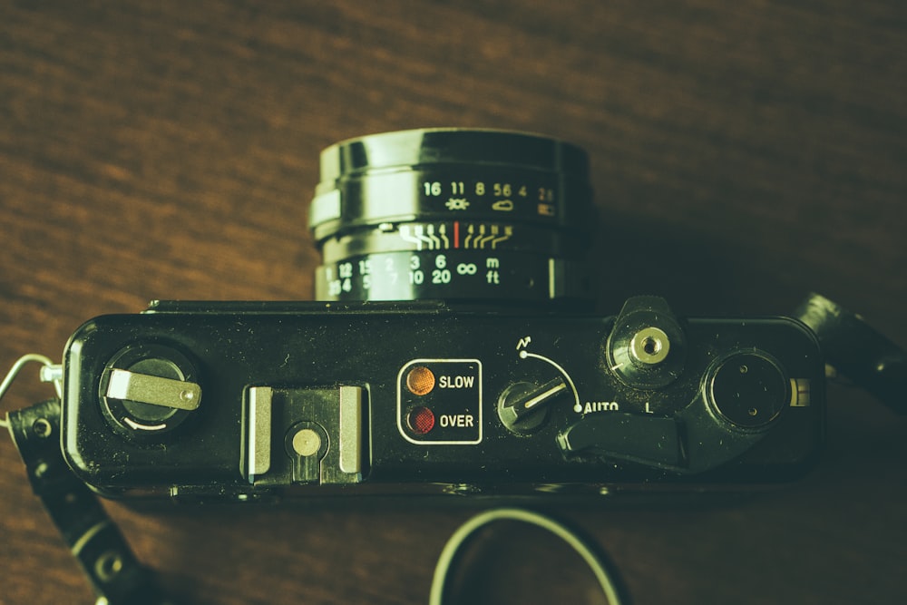 black DSLR camera on wooden surface