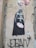 Street art on a wall depicting a character in black armor holding two heart-shaped balloons with 'Luke' and 'Leia' written on them. Next to the character, a caption reads, 'Damn... I hate holidays!' A signature or tag 'JEAN' appears at the bottom with an asterisk beside it.