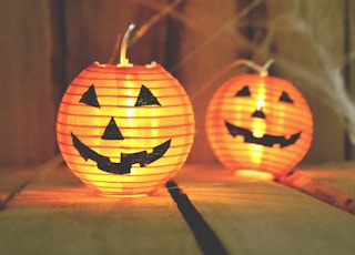 three jack-o-lantern lamps on beige wooden board