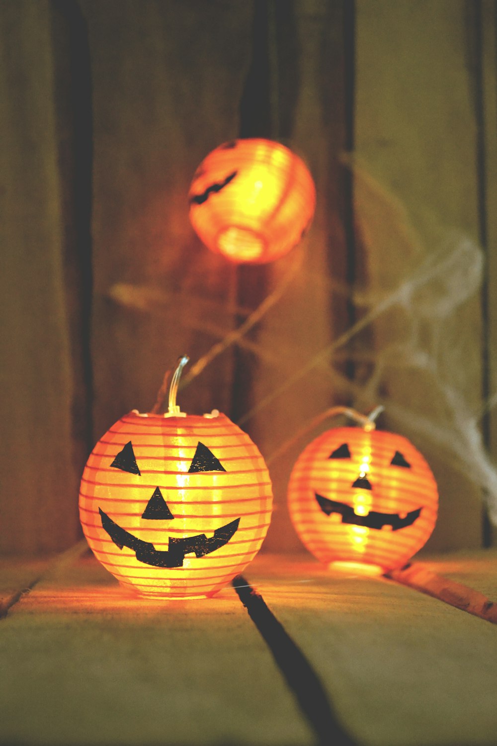 Tre lampade Jack-o-Lantern su tavola di legno beige