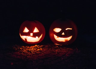 two lighted jack-o-lanterns during night time
