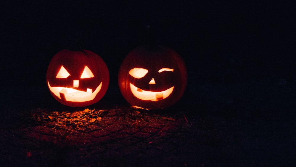 two lighted jack-o-lanterns during night time