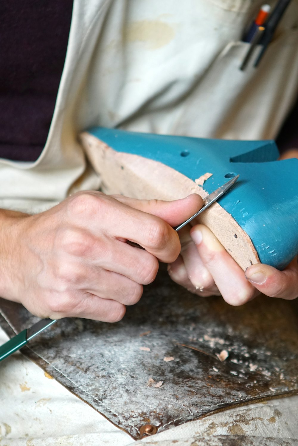 person carving blue footwear