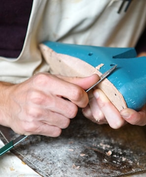 person carving blue footwear