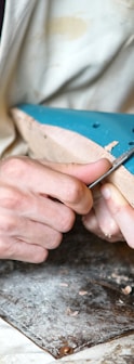 person carving blue footwear