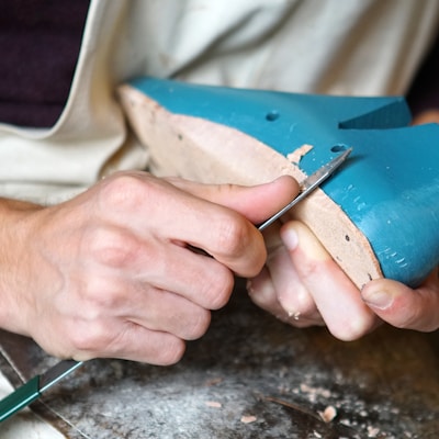 person carving blue footwear