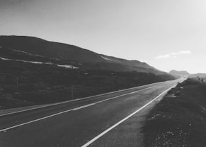 A dramatic frame from a black-and-white short film featuring a lone rider on an empty road.