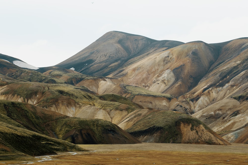 green and brown mountain under white sky photo during daytime