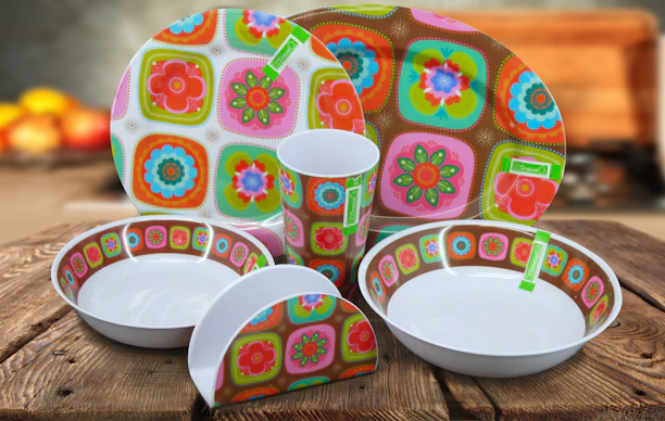 A beautifully arranged ceramic dinnerware set with soft pastel tones on a rustic wooden table.