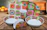 A cozy dining table set with colorful handmade stoneware plates and cups from Clay Heart.