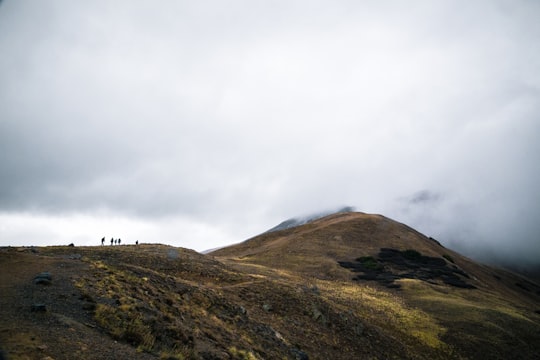 silhouette of people on mountain cliff facing fogs in Loveland Pass United States