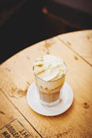 A chilled cup of creamy iced coffee with a swirl of whipped cream on top