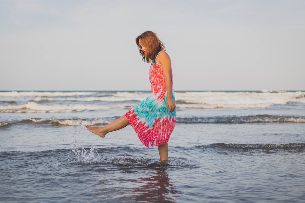 昼間、岸辺で水遊びをする女性