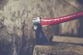 red and black axe on wood slab