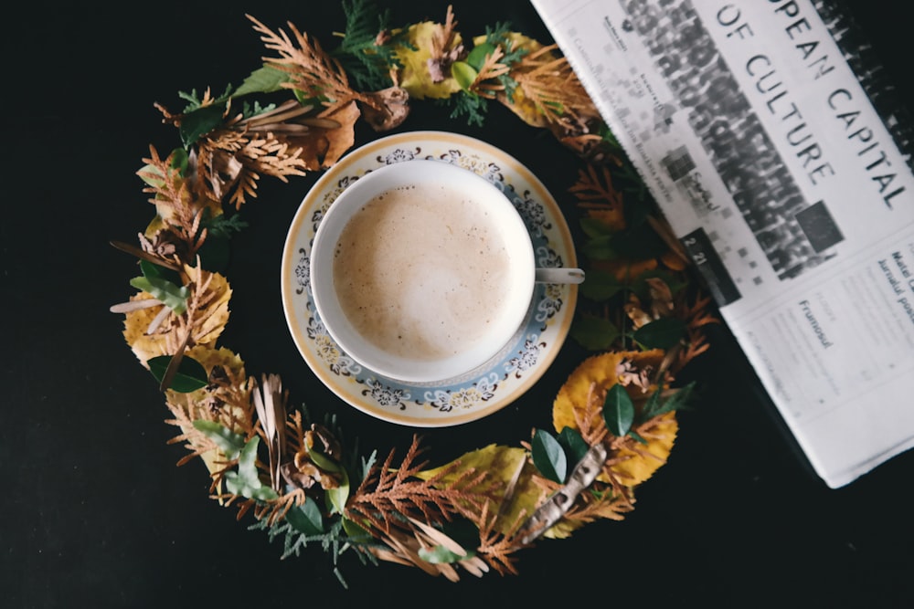 Tasse à thé en céramique blanche remplie de café sur le dessus de la soucoupe