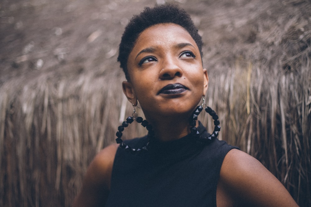 woman in black sleeveless top with black beaded hoop earrings