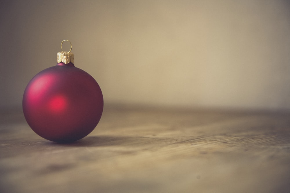 photo en gros plan de l’ornement de boule rouge sur la surface