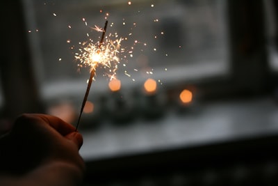 person holding sparkler jolly teams background