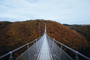 person walking on white hanging bridge during daytime