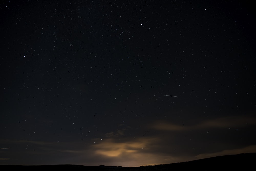 a night sky with stars and a few clouds