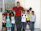 A candid photo of a man volunteering outdoors, surrounded by children.