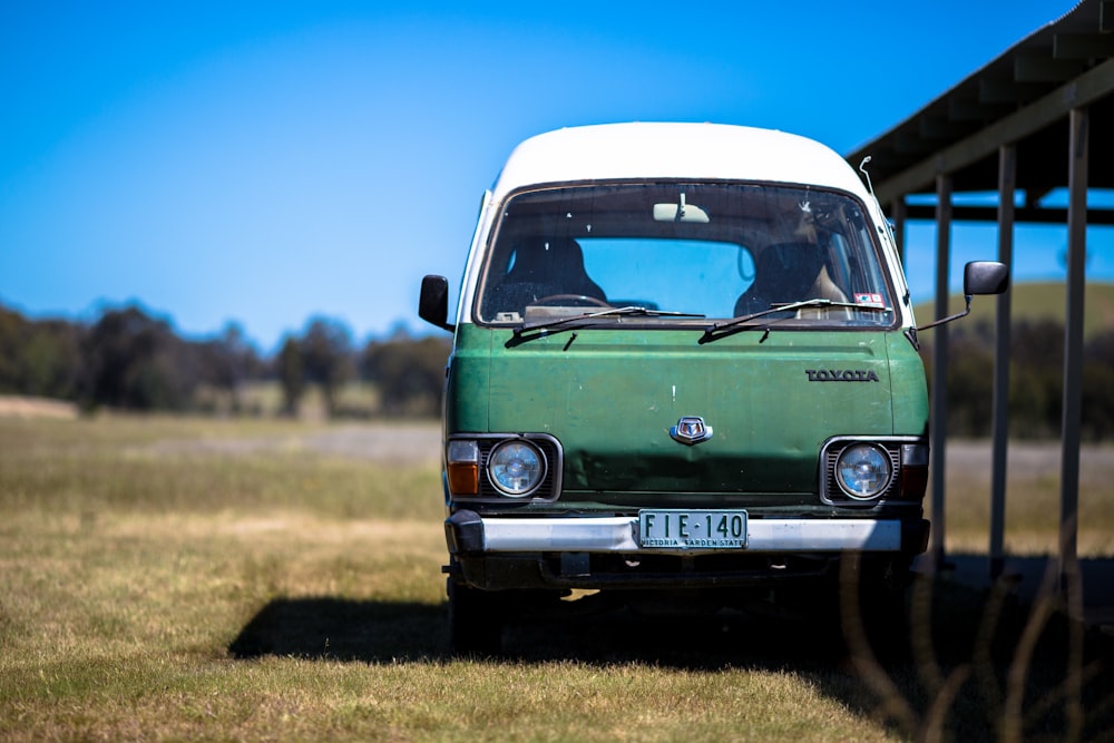 green and white Toyota vehicle parked near shed