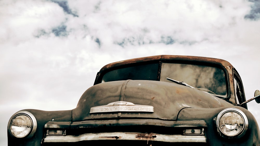 coche antiguo bajo el cielo nublado durante el día