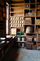 Rows of vintage bottles resting on rustic wooden shelves bathed in soft ambient light.