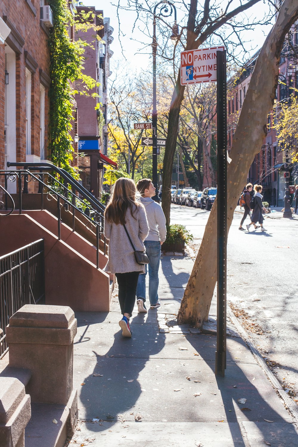 Un par de personas caminando por una acera