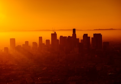 silhouette photo of city skyline orange teams background