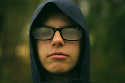 selective focus photography of man wearing eyeglasses spectacle zoom background