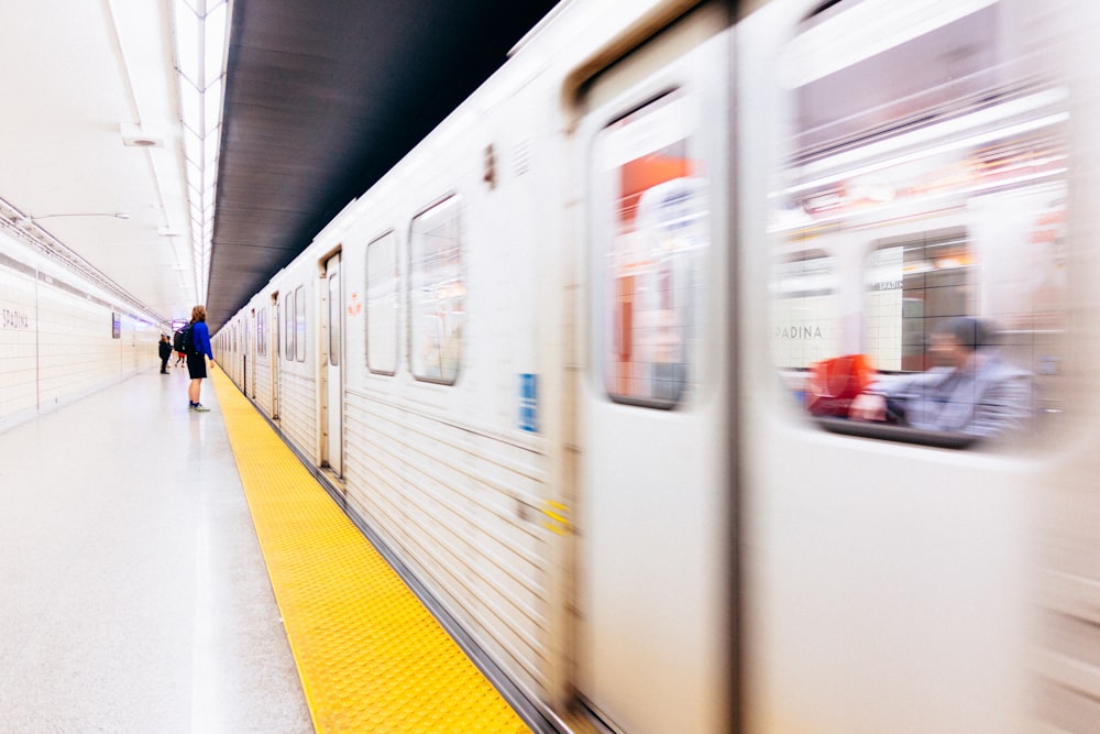 Fotografía de enfoque selectivo de una persona de pie en la estación de tren