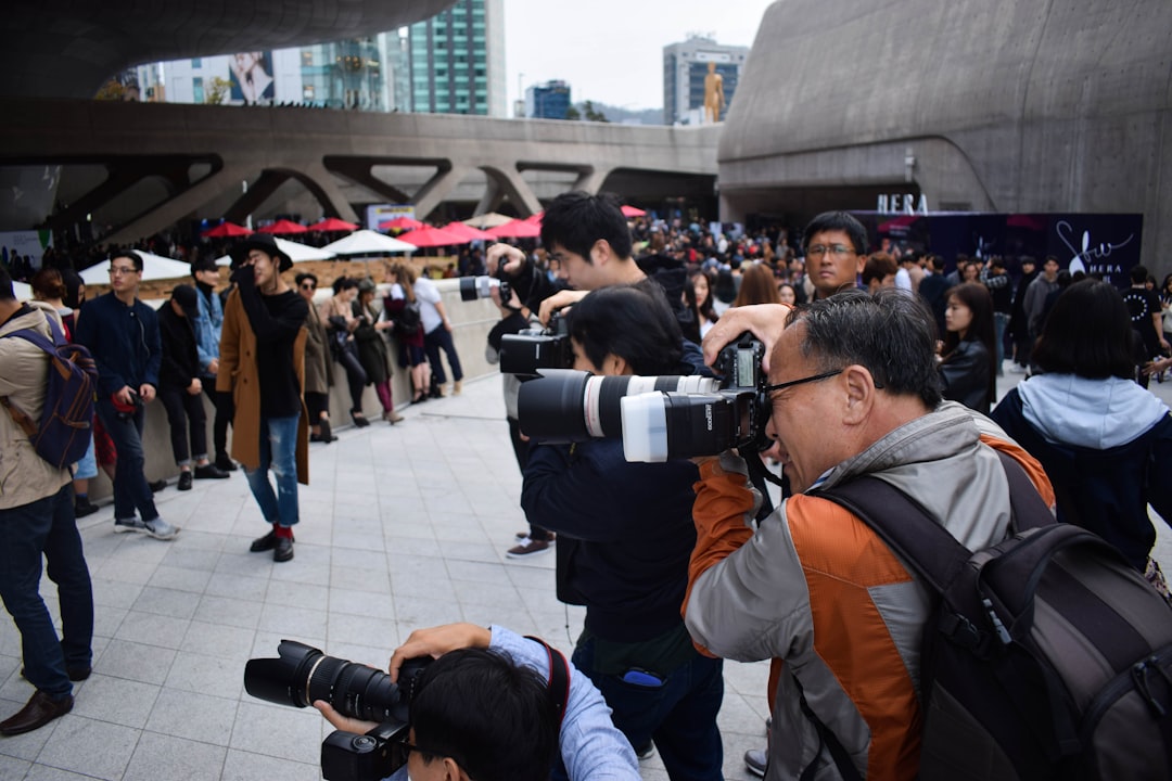 group of photographers holding DSLR cameras in event during daytime