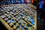 An array of wooden blocks with engraved Chinese characters, likely used for printing or stamping. The scene is vibrant, with an array of blocks neatly arranged on trays, surrounded by dim lighting. There's a focus on the intricate detail of the characters, each one carefully crafted.