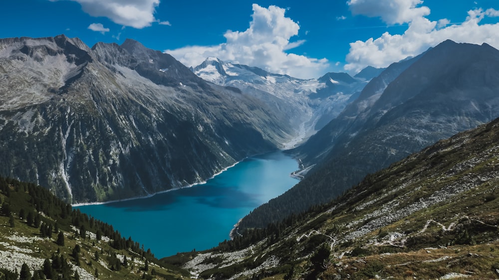 body of water between mountain range at daytime