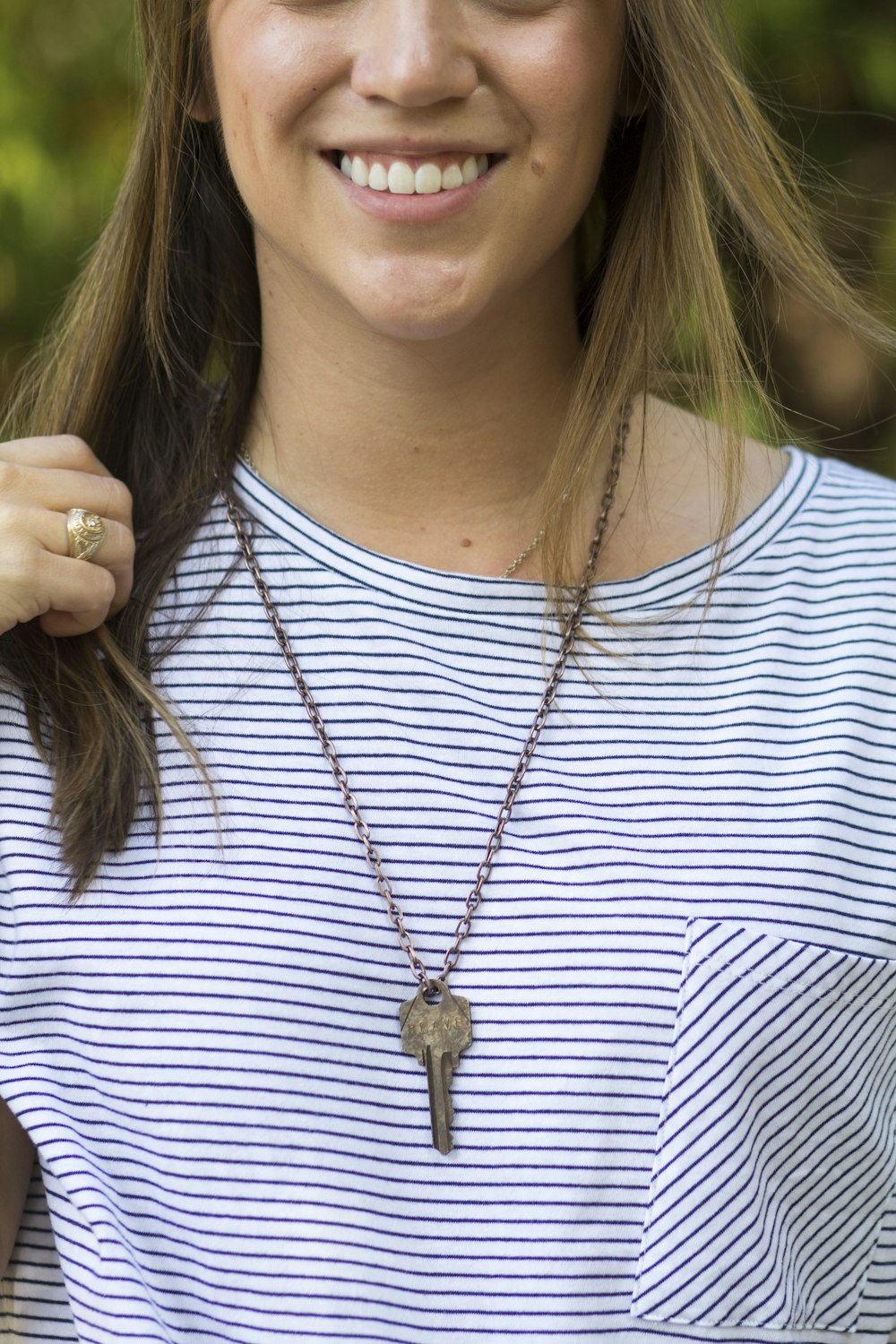 a woman wearing a striped shirt and a necklace
