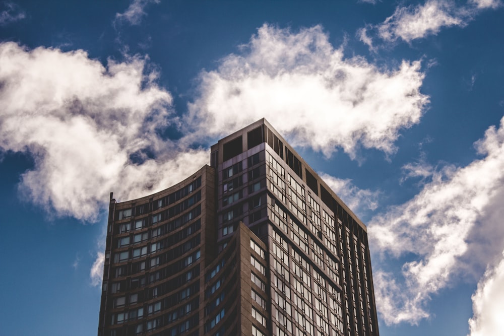 brown high-rise building under clouds during daytime