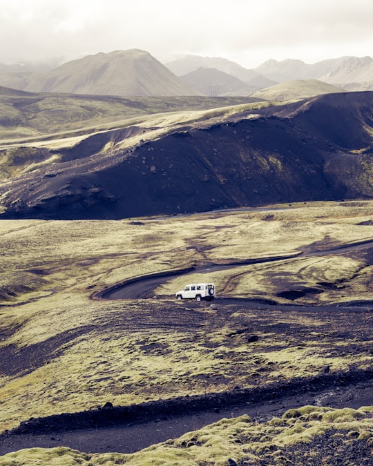 white SUV travelling on road during daytime in Landmannalaugar Iceland